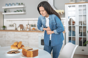 Woman grabbing her stomach in discomfort from gluten sensitivity