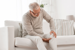 Man gripping his knee, experiencing joint pain in winter