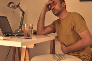 Man in chair experiencing colitis symptoms like discomfort and abdominal pain