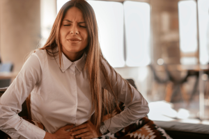 Woman having stomach pain after eating a meal