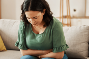 A woman doubled over with stress-related stomach pain